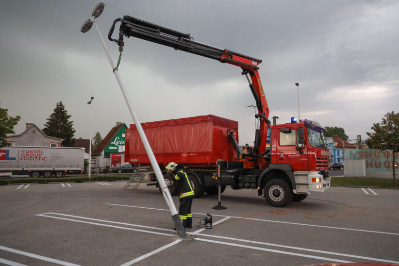 Lichtmast auf einem Parkplatz in Wels-Pernau droht nach Unfall umzustürzen