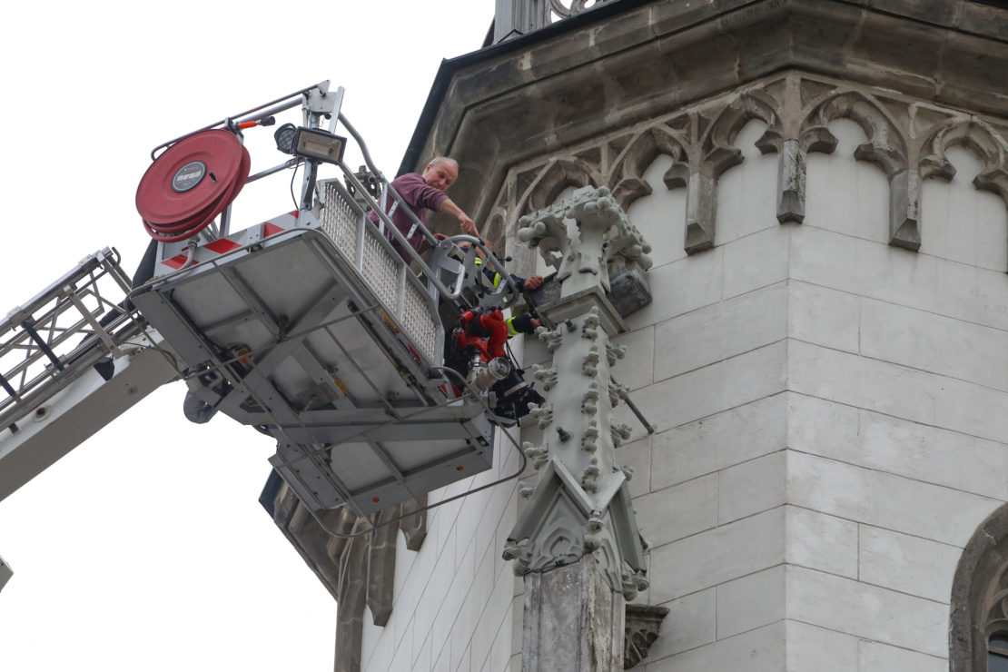Loses Fassadenelement am Turm der Evangelischen Kirche in Wels-Innenstadt durch Feuerwehr gesichert